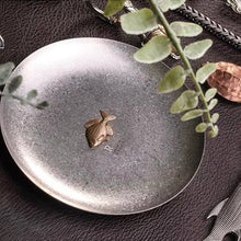 Load image into Gallery viewer, Rhodeus Plate styled on dark leather with a fish keyring and green leaves