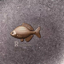 Load image into Gallery viewer, Detail of the cast brass bitterling showing its scales and fins, with the RHODEUS Designed by Wondrous stamp